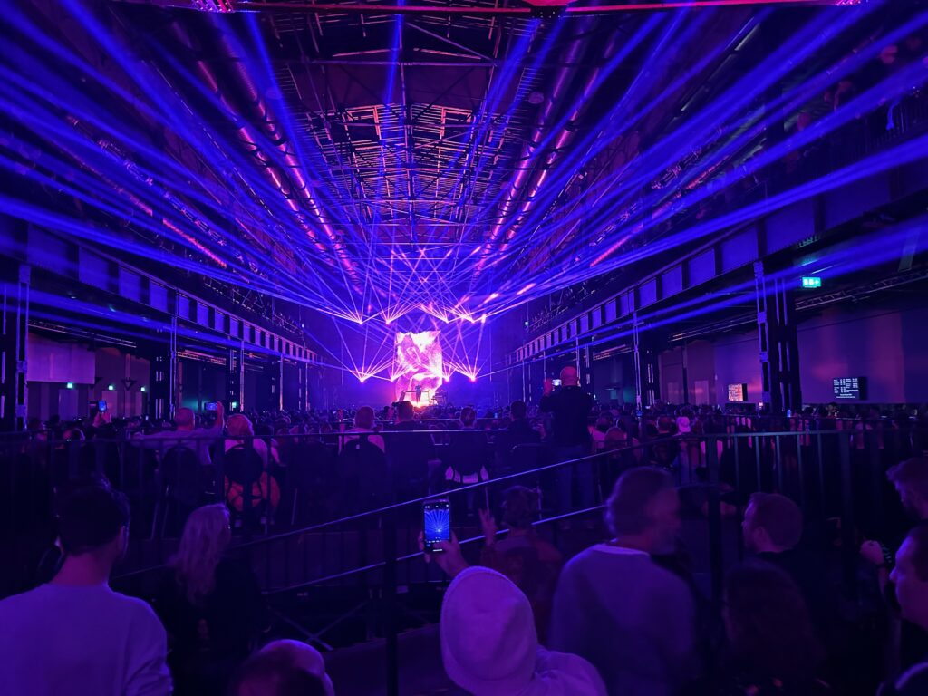 Hallenshow mit blauen Laserstrahlen über dem Publikum
