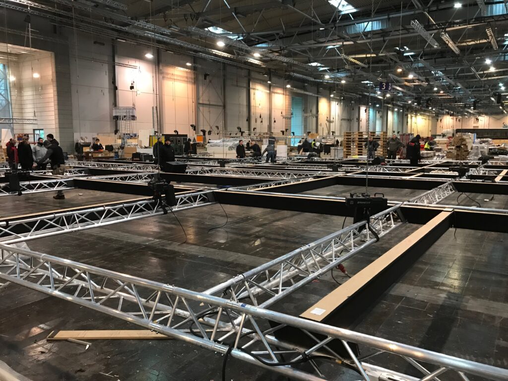 Aufbau von Traversen und Bodenplatten in einer Messehalle