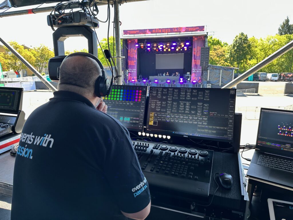 Techniker am Lichtpult vor einer Open-Air-Bühne