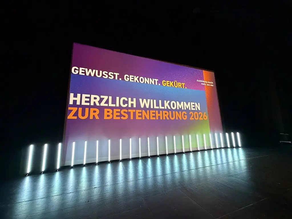 Begrüßung „Herzlich willkommen zur Bestenehrung 2026“ auf der LED-Wand mit LED-Dekolicht an der Bühnenkante