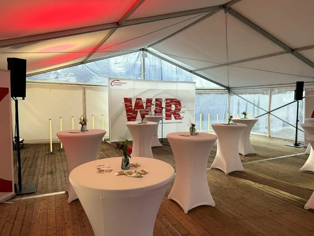 Festzelt innen mit Holzboden, Stehtischen, Beschallung und roter Ambientebeleuchtung