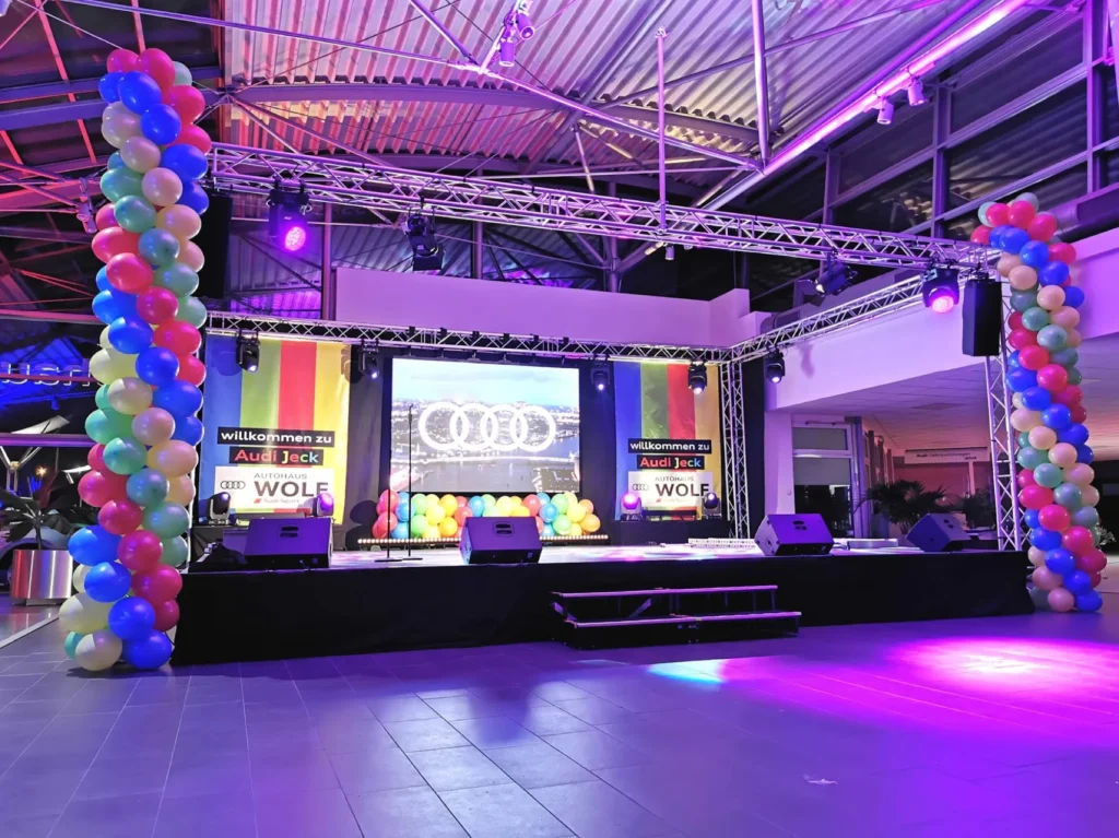 Bühne mit Ballonbögen und LED-Wand bei einer Karnevalsfeier im Autohaus